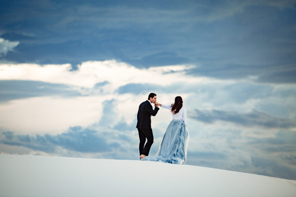 Couple walking on a san dune at sunset in formal attire at The White Sands National Monument. Photography by Shannon Cain Photography