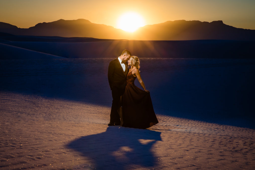 Couple taking engagement photos at The White Sands in New Mexico at sunset. Photo by Shannon Cain Photography
