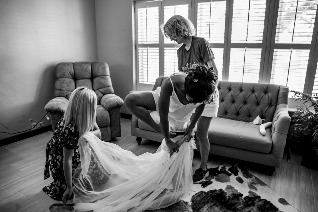 Bride gets into wedding dress at Bergheim Ranch in Boerne.  Photo by Shannon Cain Photography