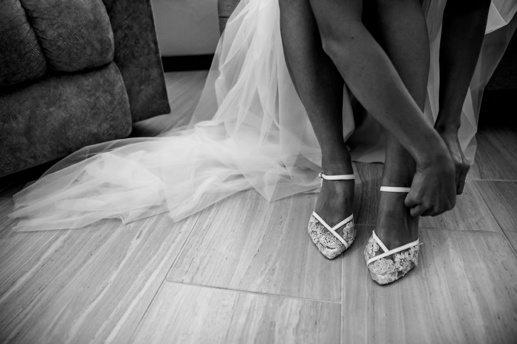 Bride puts on wedding shoes at Bergheim Ranch in Boerne.  Photo by Shannon Cain Photography