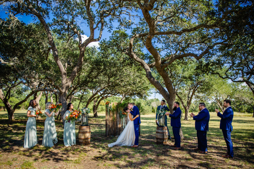 Bride and Groom's first kiss under the oak trees at Bergheim Ranch in Boerne.  Photo by Shannon Cain Photography