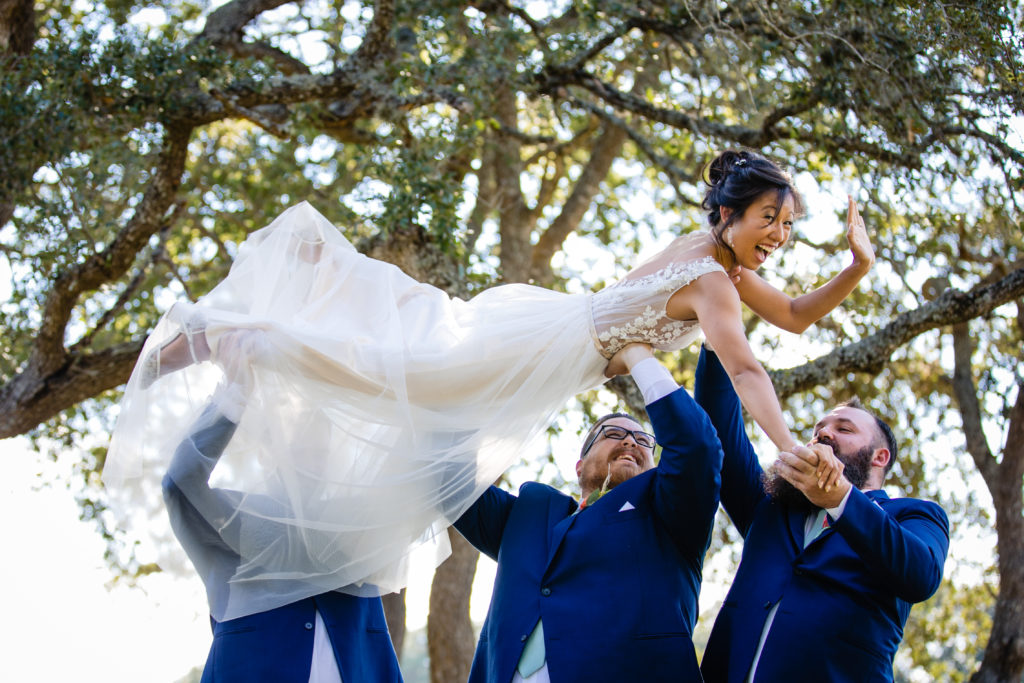 Groomsmen hold up bride at Bergheim Ranch in Boerne.  Photo by Shannon Cain Photography