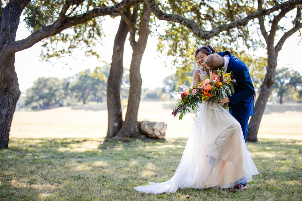 Groom lovingly kisses the bride and it makes her giggle at Bergheim Ranch in Boerne.  Photo by Shannon Cain Photography