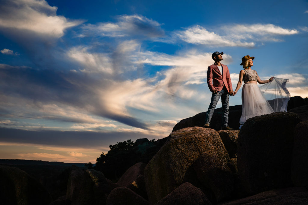 Bride and groom pose in the clouds at Enchanted Rock State Park.  Photography by Shannon Cain Photography