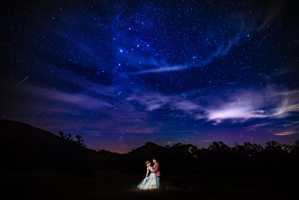 Bride and Groom hold each other under the stars at Enchanted Rock State Park.  Photography by Shannon Cain Photography
