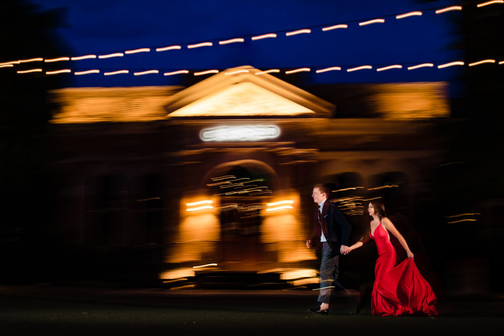 Couple in formal outfits run for creative portrait at The Pearl Historic District in San Antonio, TX in formal attire. 